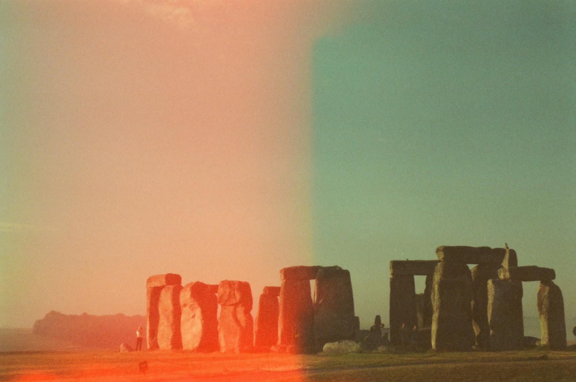 Mystical view of Stonehenge captured in vintage analog style with light leak effect.